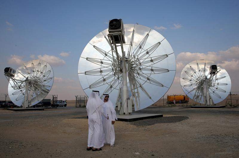 男子站在迪拜Mohammed bin Rashid Al Maktoum太阳能公园的太阳能电池板前。 男子站在迪拜Mohammed bin Rashid Al Maktoum太阳能公园的太阳能电池板前。
