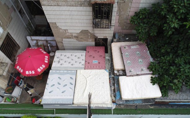 小区外墙掉瓷砖20年，5年前被鉴定为危房，无奈用床垫挡瓷砖雨