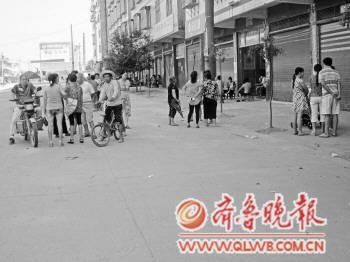 江口镇大街上，一些孩子吃过“营养餐”的家长聚在一起，讨论转基因话题。