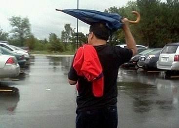刮台风常下雨,得带好雨具.下面这位大哥,你能好好撑伞么?