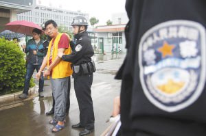 犯罪嫌疑人李志祥在茶叶店前指认现场    都市时报见习记者 王中杰