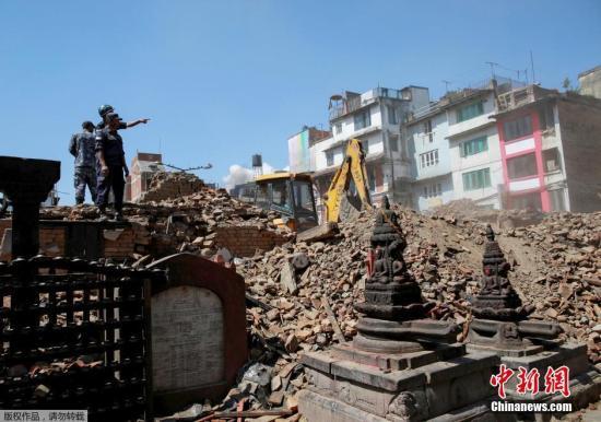 当地时间2015年4月27日，尼泊尔加德满都，尼泊尔警察在一处坍塌的庙宇徒手清理瓦砾，寻找幸存者。