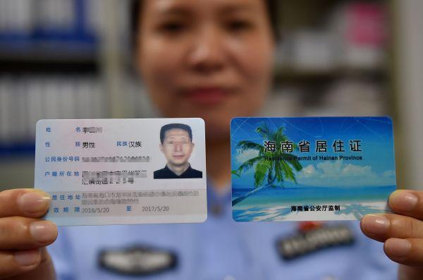 5月20日,海口市海垦派出所的民警展示首张发放的居住证.