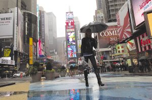 纽约近日气温骤降，最低只有12摄氏度，一名行人冒雨走在时代广场上。 