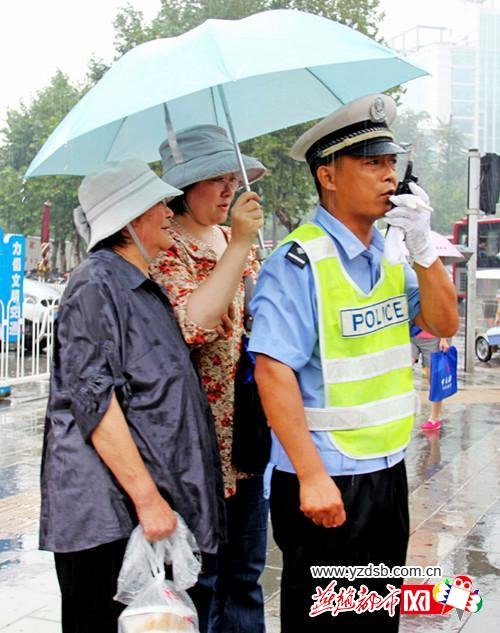 交警雨中执勤一个多小时 市民为其撑伞感动路人
