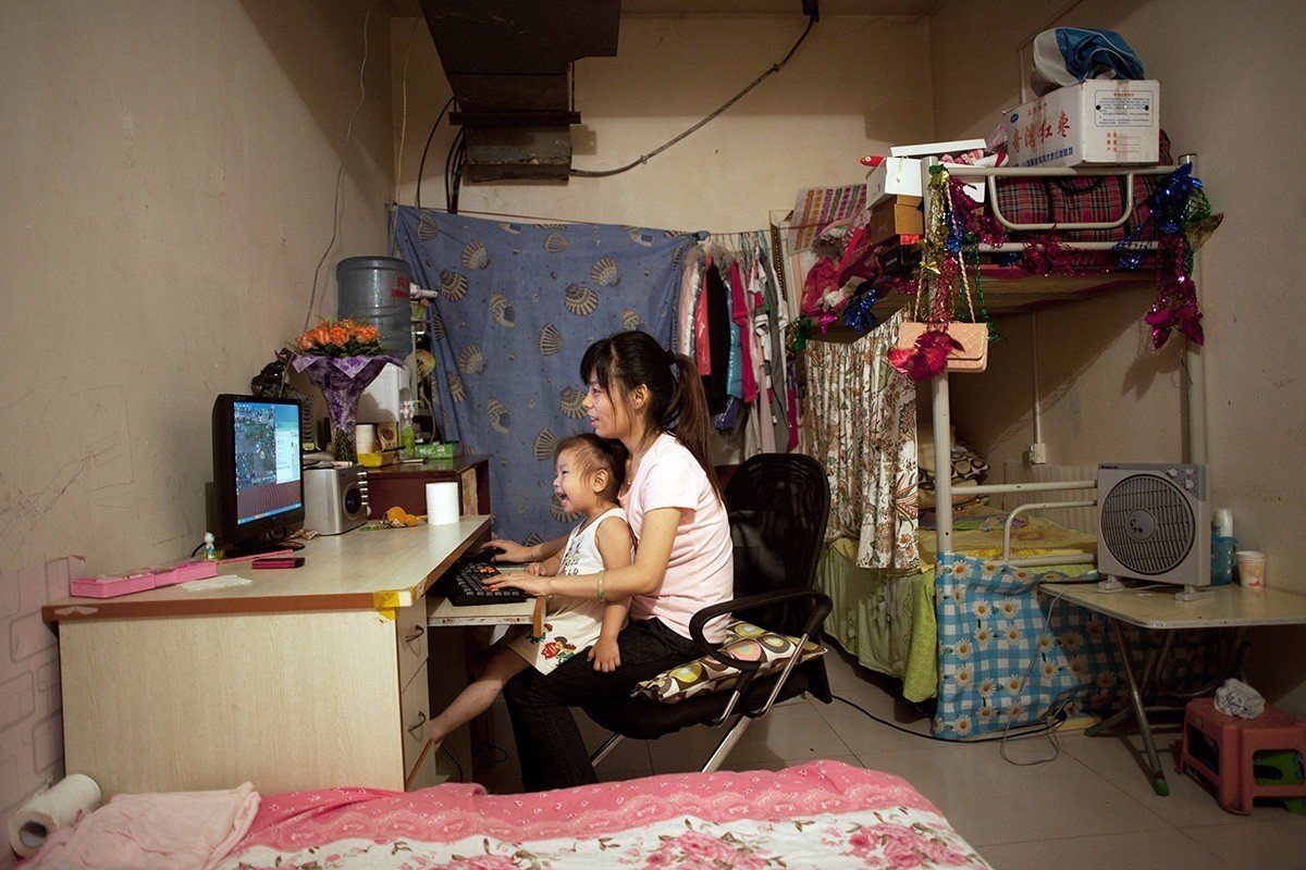 在北京西部的地下室中的最大的一间房子里,25岁的季兰兰(音译)与她3岁的女儿正在玩游戏。季兰兰已经在这里住了四年了。《北京地下的蜗居世界》,北京,2011 在北京西部的地下室中的最大的一间房子里,25岁的季兰兰(音译)与她3岁的女儿正在玩游戏。季兰兰已经在这里住了四年了。《北京地下的蜗居世界》,北京,2011