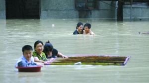 昨日,湖北咸宁,市民在洪水中转移家中物资。 远征 摄