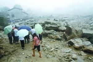 昨日,在湖南岳阳市临湘市詹桥镇观山村发生山洪泥石流,村民在泥石流旁行走。武席同 摄