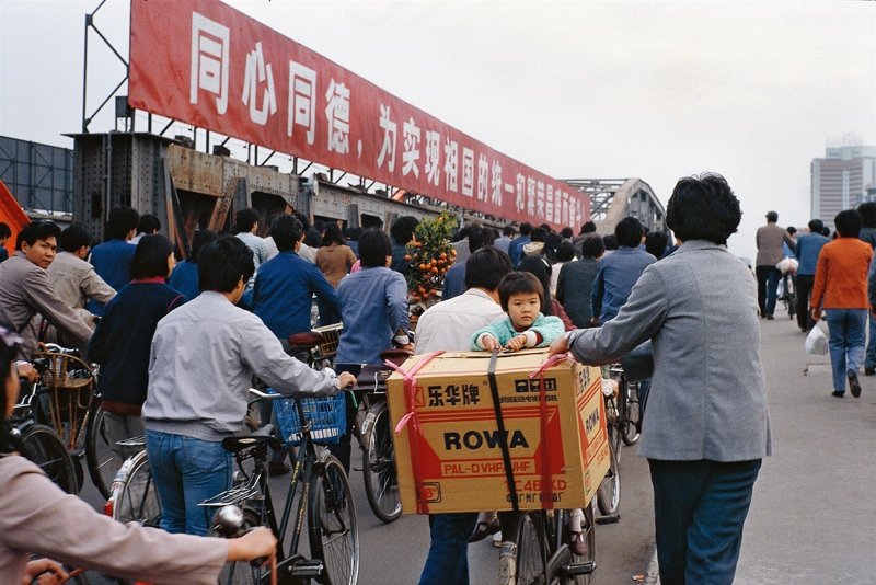 70年代末80年代初开始,电视机开始走进人们的家庭,带来了更多信息和外面世界的面貌。图为一位市民把刚刚购买的彩色电视机放到自行车后座上拉回家。 70年代末80年代初开始,电视机开始走进人们的家庭,带来了更多信息和外面世界的面貌。图为一位市民把刚刚购买的彩色电视机放到自行车后座上拉回家。