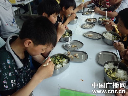 望江县莲州中心学校的孩子们在吃午餐:黄瓜炒肉