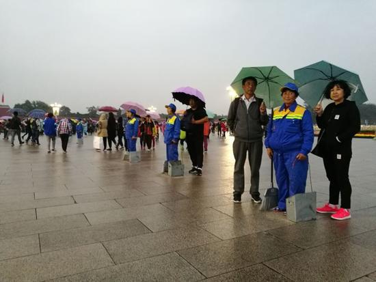 感人!天安门广场游客自发为环卫工打伞