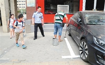 家长反对学校门前设车位 自费买漆抹去停车线