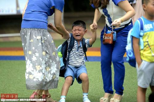 2014年09月01日，山东省济南市中小学开学第一天，在济南汇文实验学校，一年级新生拉着家长的手走进校园，有的孩子看到父母离开后大声哭泣，一个个哭成了小泪人。（资料图片）
