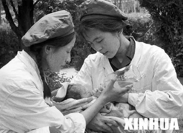 解放军某部的医务人员在护理地震后第二天出生的婴儿