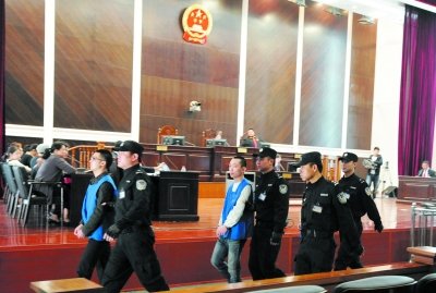 王安安(左),王伟(右)被法警带出法庭.