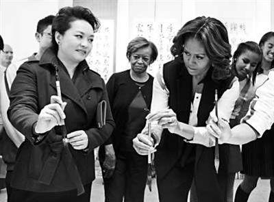 彭丽媛向米歇尔示范如何握笔