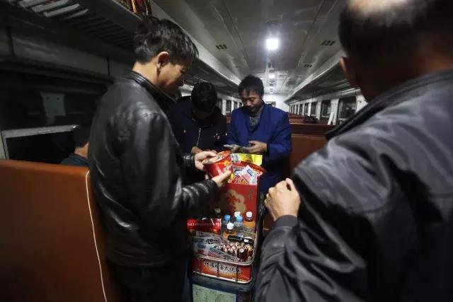 火车上在食品小推车前进行挑选的乘客。图片来源/视觉中国 火车上在食品小推车前进行挑选的乘客。图片来源/视觉中国