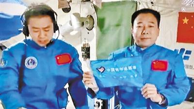 航天员景海鹏(右)手执"飞天旗帜".