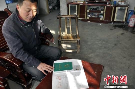 村民朱正东向记者出示自己的土地承包证件。吴奇勇摄