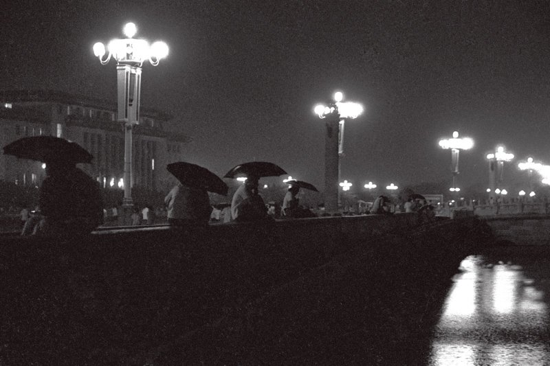 20世纪70年代末期,晚上在广场谈恋爱的年轻人。小雨中,恋人们撑着伞偎依在一起。 20世纪70年代末期,晚上在广场谈恋爱的年轻人。小雨中,恋人们撑着伞偎依在一起。