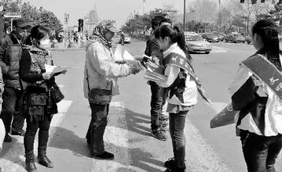 大学生送环保袋劝阻行人闯红灯效果明显(图)