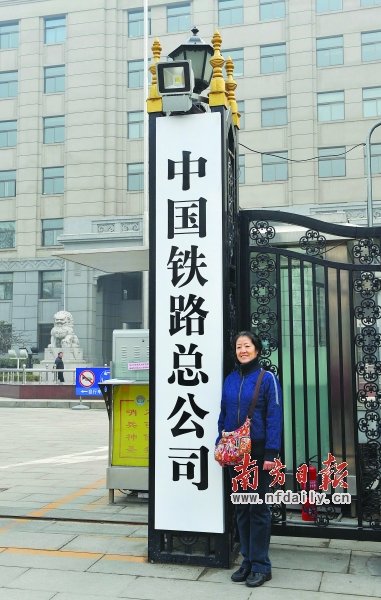 17日,一名市民在中国铁路总公司门牌前留影。新华社发