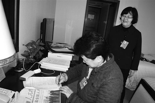 有代表来找赵冬苓（站立者）为议案签名。 