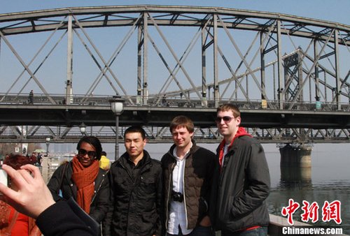 外国游客在中朝边境鸭绿江畔合影(图)