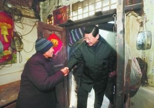 习近平在龙泉关镇骆驼湾村看望困难群众唐荣斌家。