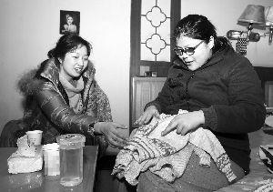 工作人员为乐燕（右）即将出生的孩子准备了小毛衣