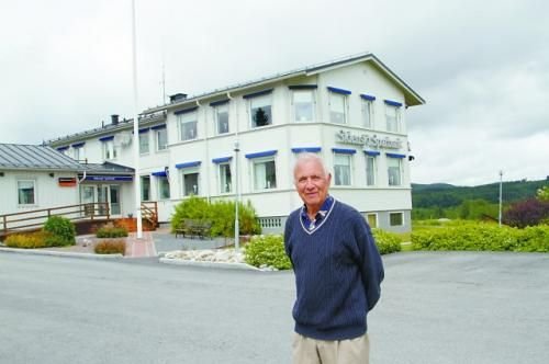 丝湖村银行原董事长尤纳斯在银行前讲述银行的历史。