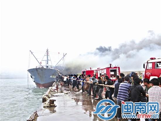 福建晋江一渔船失火 几十名陌生人冒雨拉绳救火