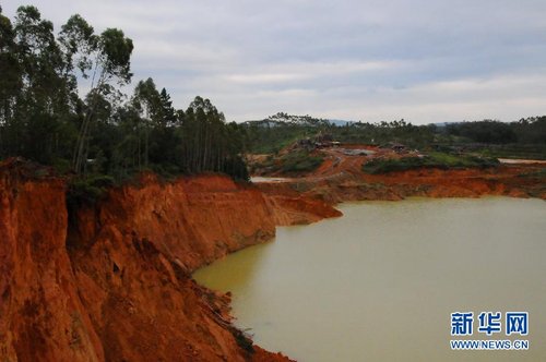 图为清湖镇平安村一处巨大矿坑，边坡随时有崩塌危险，远处是作业矿点（11月9日摄）。近日，有网友在国内某网站发帖称：广西陆川县清湖镇多年来非法乱占耕地、林地开采钛铁矿猖獗，导致当地2万多亩林地被挖、1万多亩基本农田被毁、近20名学生溺水身亡。网帖附有多张图片，画面触目惊心。就网帖中反映的问题，新华社“中国网事”记者近日前往陆川县进行了调查。新华社记者 张周来