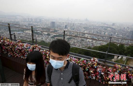 资料图：当地时间2015年6月8日，韩国，游客戴口罩防止感染中东呼吸综合征(MERS)。