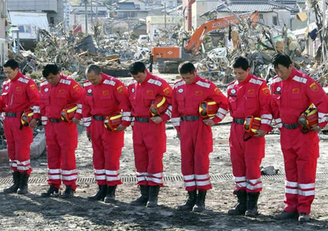 新闻资料图：2011年3月，中国国际救援队向日本地震遇难者默哀