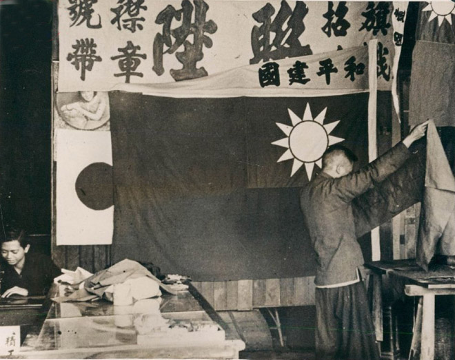 图:1940年,日占时期广州的制旗铺,正在制作汪伪政权版的“青天白日旗”,可以很清晰地看到旗帜上的“和平建国”猪尾巴。 图:1940年,日占时期广州的制旗铺,正在制作汪伪政权版的“青天白日旗”,可以很清晰地看到旗帜上的“和平建国”猪尾巴。