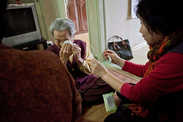 一位义工(右)正在试着宽慰今年89岁在首尔独居的老人尹占桃 一位义工(右)正在试着宽慰今年89岁在首尔独居的老人尹占桃