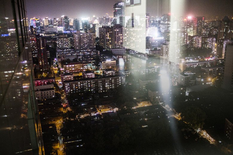 从国贸一个写字楼高层往下看,夜晚的cbd灯火通明,而中间这块没有灯光