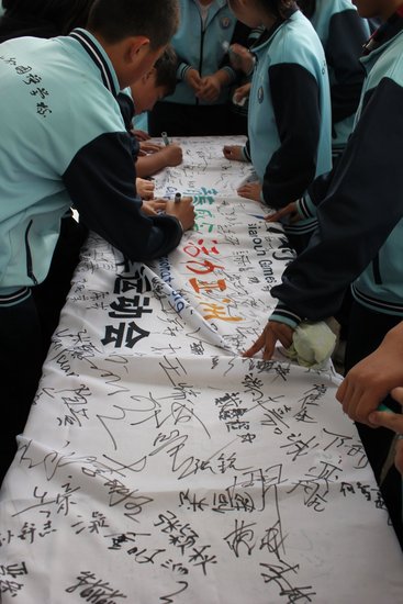 东山外国语学校举行亚青会会旗校旗签字活动