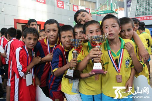 新疆青少年足球联赛闭幕 小球员高举奖杯合照