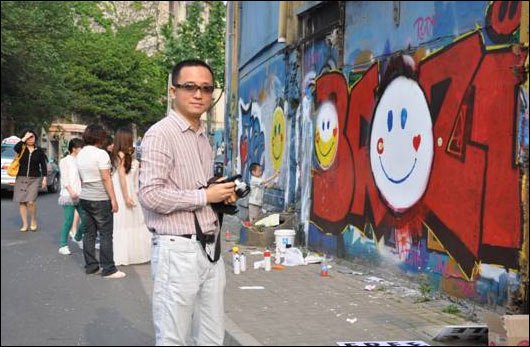盛大游戏CEO谭群钊在微笑涂鸦墙前参与活动