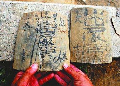 从墓室中发现的写有"镇墓大吉"等字样和图案的瓦片
