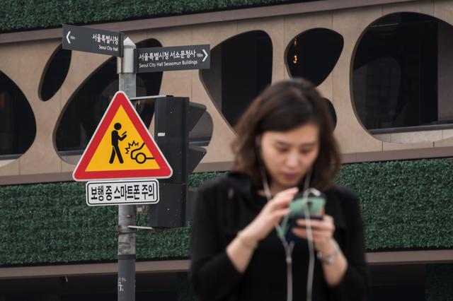 韩国推出手机低头族专用警示牌  避免发生交通事故
