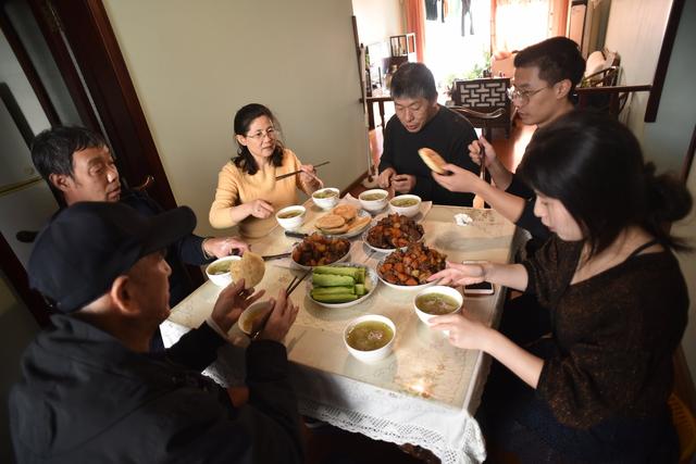 小郭一家人围坐吃柴火饭.