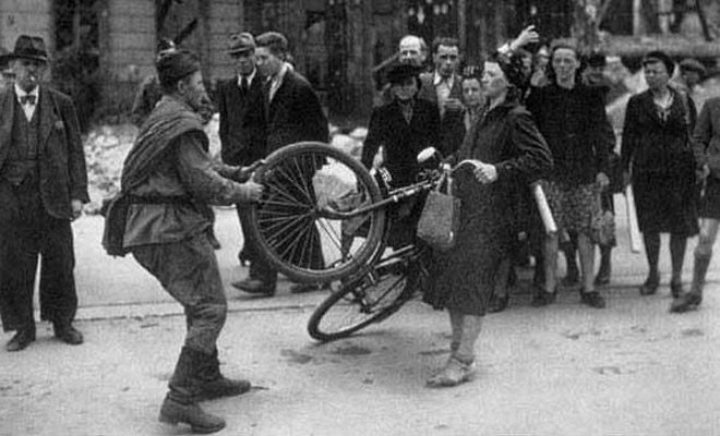 一名苏军士兵试图抢夺德国妇女的自行车