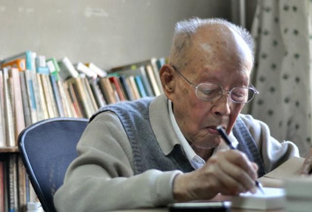 图注:晚年伏案写作的周有光