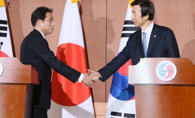 日本外相岸田文雄(左)与韩国外长尹炳世(右)在12月28日的联合记者会上握手 日本外相岸田文雄(左)与韩国外长尹炳世(右)在12月28日的联合记者会上握手