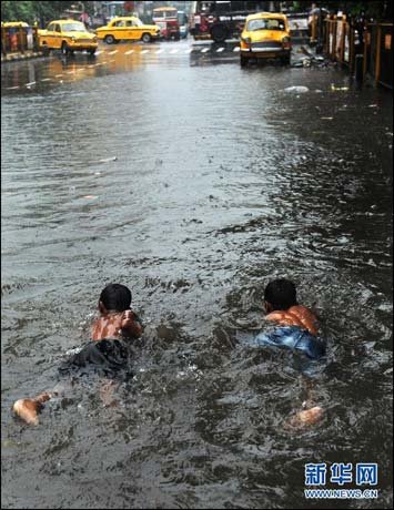 印度加尔各答降暴雨 孩童在街上游泳(图)_实况