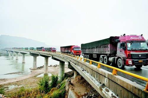 大型运煤车排队缓慢从神盘公路通过黄河大桥驶