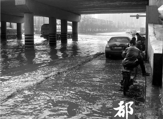 桥洞下积水成湖吓住小轿车 系私接管道所致